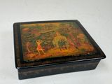 une boîte noire ornée d'une peinture, posée sur une table