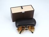 Lunettes de soleil Ray-Ban dans leur boîte et leur étui, posées sur une surface blanche