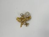 un gros plan d'une broche en or ornée de fleurs et de feuilles