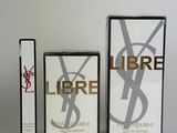 two boxes of perfume sitting next to each other on a white surface
