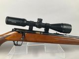 a rifle with a scope mounted on top of it