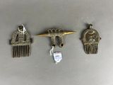 three antique hair combs and a hair clip on a table