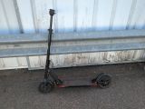 un scooter posé par terre à côté d'un banc