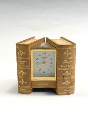 une petite horloge fabriquée à partir de vieux livres, posée sur une table