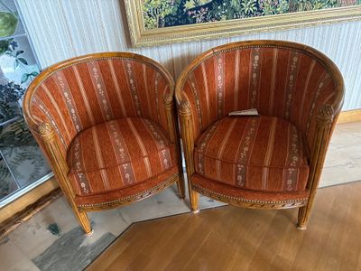 une paire de chaises rayées orange devant un tableau accroché au mur
