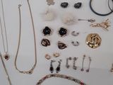 many different necklaces and bracelets displayed on a table