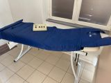 un drap bleu posé sur une table blanche devant une fenêtre