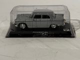 a toy car in a clear case on a white surface