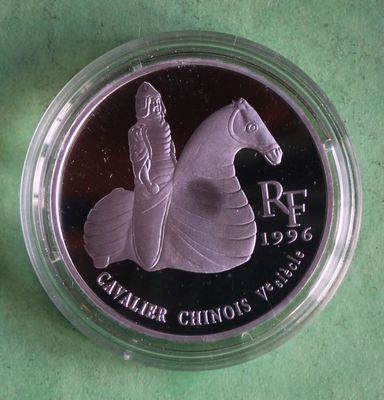 the coin is in a plastic container on a green surface