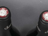 two bottles of wine sitting next to each other on a table