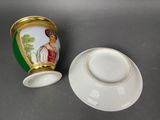 a cup and saucer sitting next to each other on a table