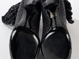 pair of black women ' s shoes with bows on them on a white surface