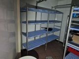 une petite salle de bains équipée de toilettes et d'étagères
