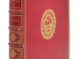 un vieux livre rouge avec un emblème doré sur la couverture
