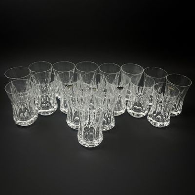 six verres transparents sont alignés sur une surface noire