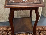 une petite table avec un plateau en marbre posée sur un tapis
