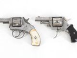 two old revolvers are sitting side by side on a white surface