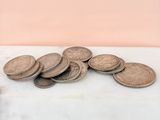 a pile of coins sitting on a table next to a bottle of beer