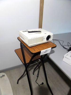 une photo d'un projecteur posé sur un pied dans une pièce