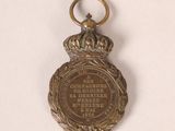 an old medal with a crown on top of it on a white surface