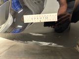 a man that is kneeling down next to a car