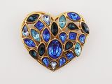 a close up of a heart shaped brooch with blue and green stones
