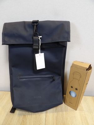 backpack with tag and cardboard box on wooden floor next to wall