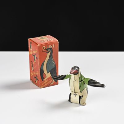 une petite figurine de pingouin posée à côté d'une boîte d'allumettes