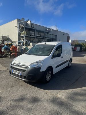 une camionnette blanche garée devant un bâtiment dans un parking
