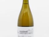 une bouteille de vin blanc posée sur une table blanche