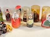 many different types of glass vases with dolls in them