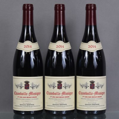 three bottles of red wine are lined up on a table