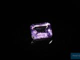 une pierre d'améthorate violette posée sur une surface noire