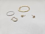 three pairs of gold and silver rings on a white surface