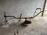 une charrue à l'ancienne posée sur le sol d'un bâtiment