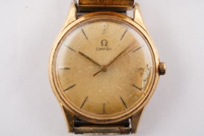 an image of a gold wrist watch on a white surface
