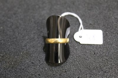 a ring with a gold band sitting on top of a black surface