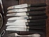 a lot of knives and spoons on a table