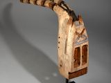 une image d'une sculpture en bois représentant un oiseau sur un support