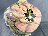 un vase orné d'une fleur sur fond gris