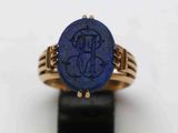 Gros plan sur une bague en or ornée d'une pierre bleue