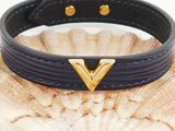 black leather bracelet with a gold v on the front