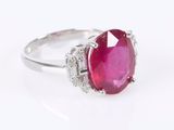 a close up of a ring with a pink stone surrounded by diamonds
