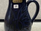un vase bleu posé sur une table, avec une étiquette de prix dessus