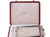 an open red case with a silver tray inside of it