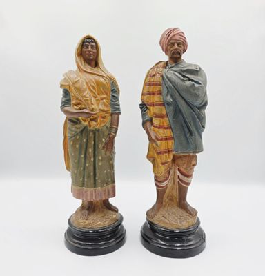 deux figurines d'un homme et d'une femme debout l'un à côté de l'autre
