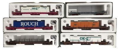 six wagons de train miniature se trouvent dans une boîte posée sur une surface blanche