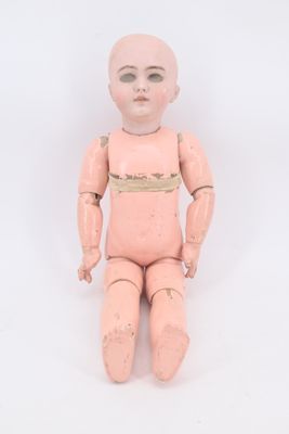 a small doll sitting on a white surface with a white background