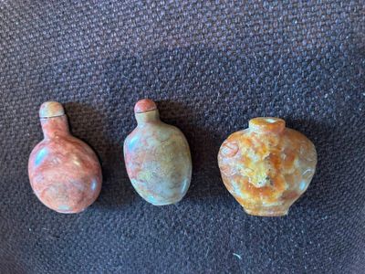 trois petits vases posés les uns à côté des autres sur une surface noire