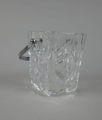 un verre en verre transparent muni d'une anse, posé sur une table
